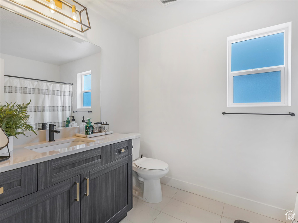 Full bathroom featuring vanity, tile patterned flooring, and a shower with curtain