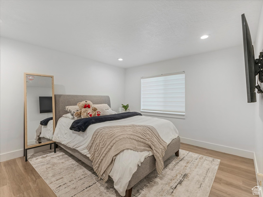 Bedroom with wood finished floors and recessed lighting