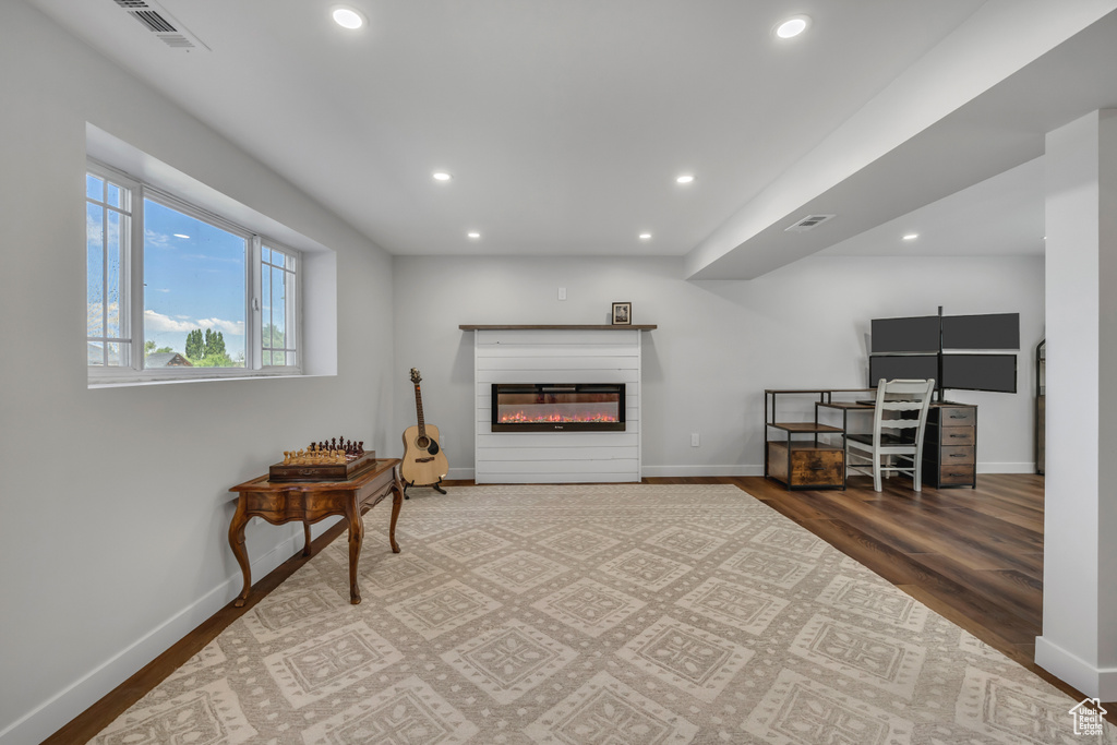 Living area featuring recessed lighting, wood finished floors, and a glass covered fireplace