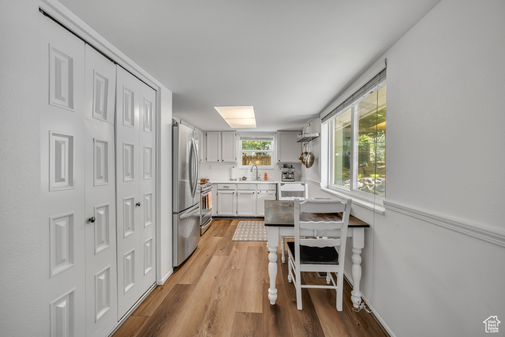 Kitchen featuring appliances with stainless steel finishes, light wood-type flooring, and light countertops