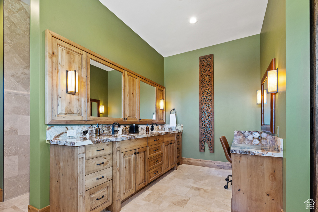 Bathroom featuring double vanity and baseboards