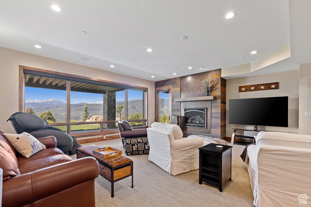 Living area featuring light carpet, recessed lighting, and a fireplace