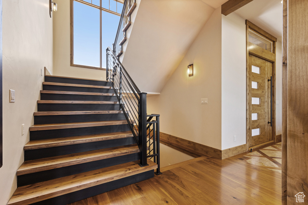 Stairs featuring wood finished floors and baseboards