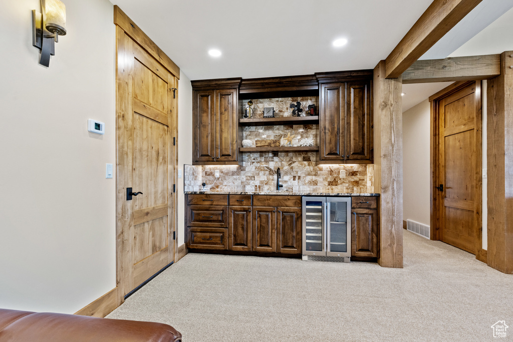 Indoor wet bar featuring beverage cooler, light carpet, recessed lighting, and tasteful backsplash