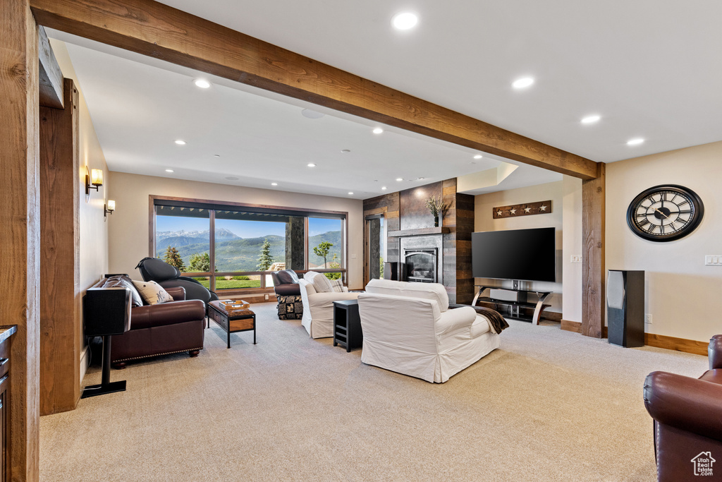 Living area with light carpet, recessed lighting, beam ceiling, and a fireplace