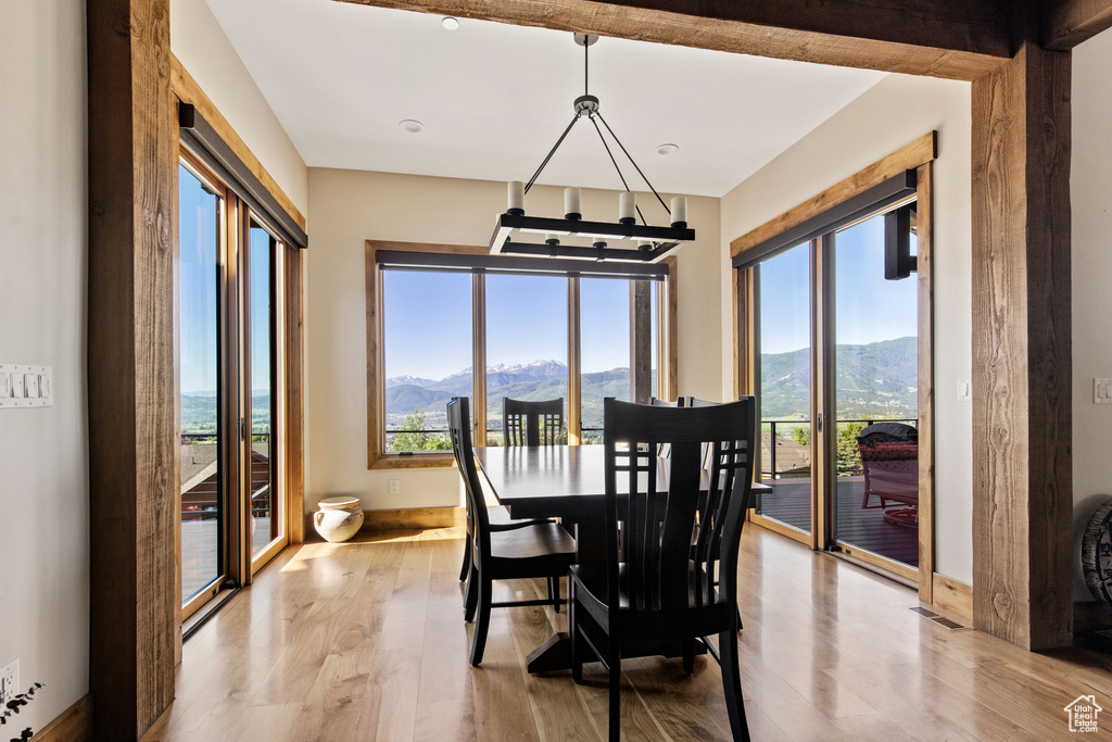 Dining room with a mountain view, wood finished floors, and a chandelier