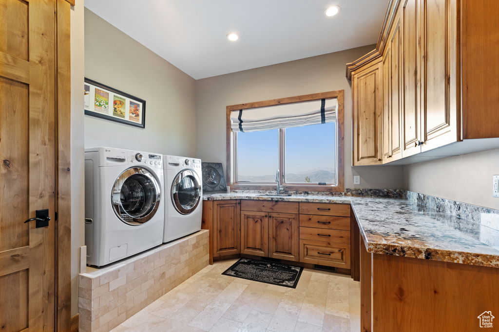 Laundry area with cabinet space, washing machine and dryer, and recessed lighting