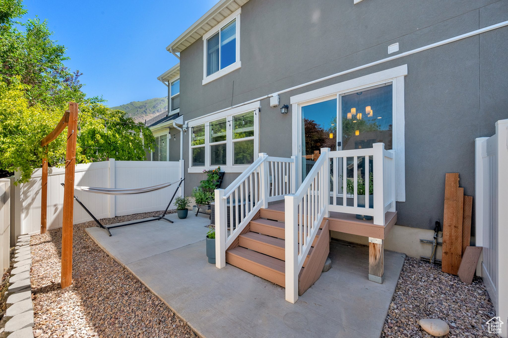 Rear view of house featuring stucco siding, a patio, and a mountain view