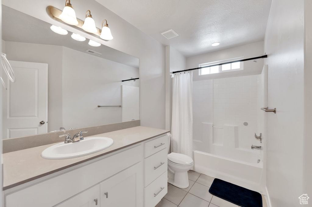 Bathroom featuring tile patterned flooring, vanity, and shower / tub combo