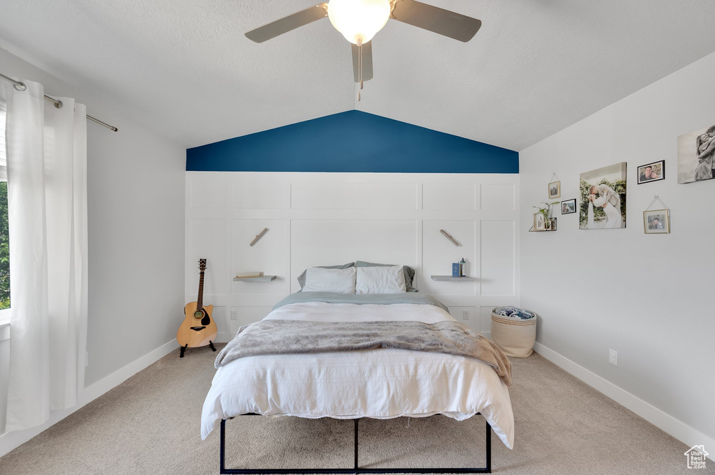 Bedroom with light carpet, lofted ceiling, and ceiling fan
