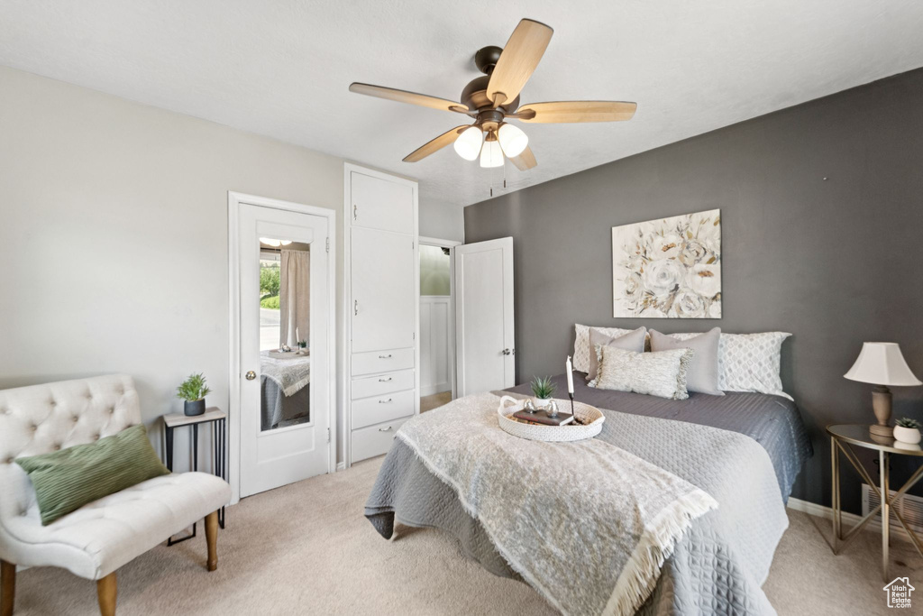 Bedroom with light carpet and a ceiling fan