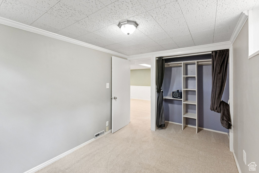 Unfurnished bedroom featuring carpet floors and crown molding