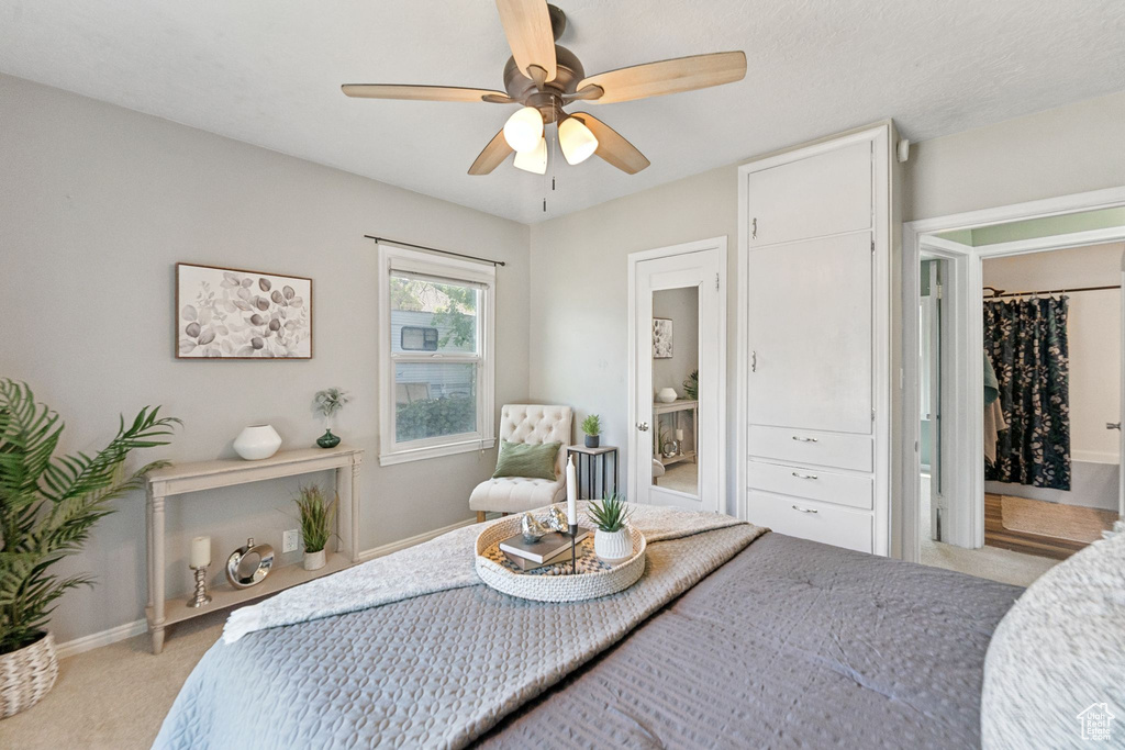 Bedroom featuring light colored carpet, a ceiling fan, and ensuite bathroom