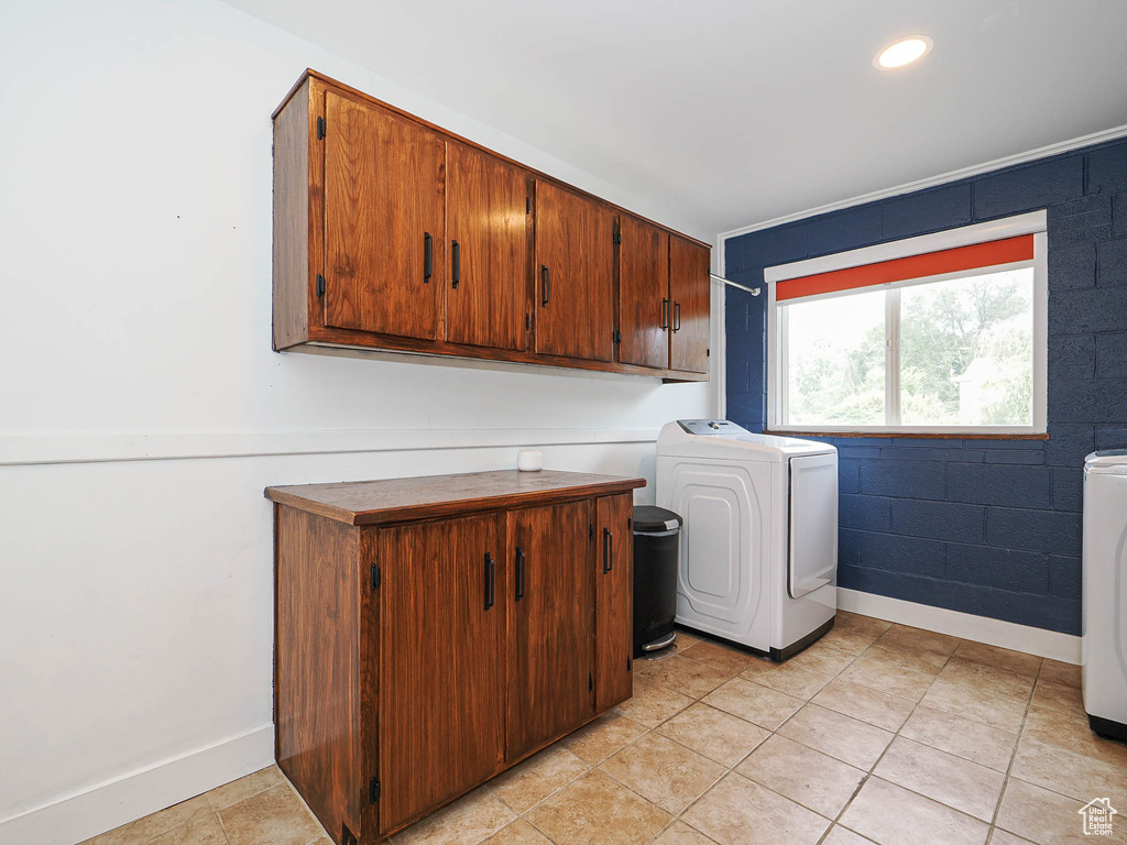 Washroom with cabinet space, light tile patterned floors, washer and dryer, and recessed lighting