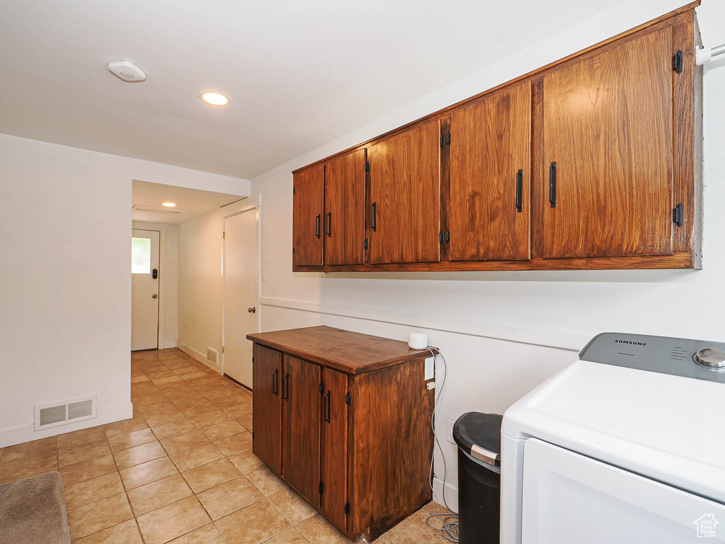 Laundry area featuring washer / clothes dryer, cabinet space, recessed lighting, and light tile patterned flooring