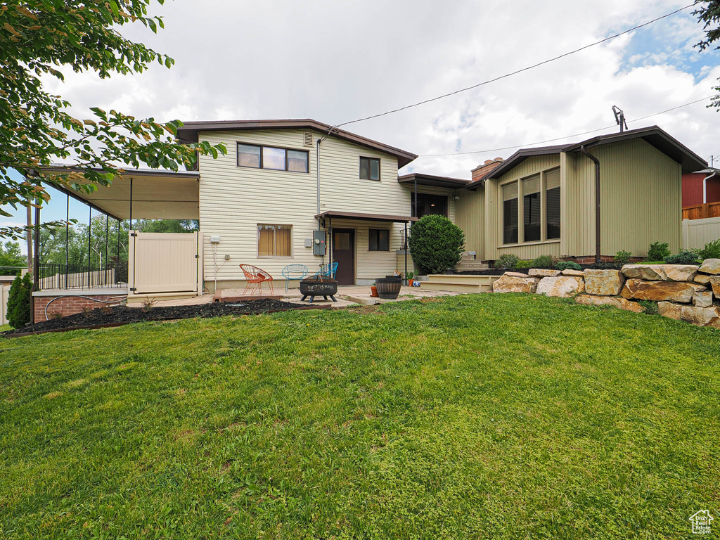 Back of property with a patio and a fire pit