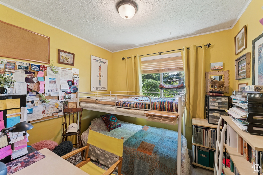 Bedroom featuring a textured ceiling and ornamental molding
