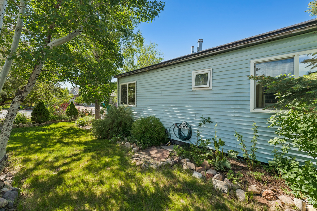 View of side of home featuring a yard