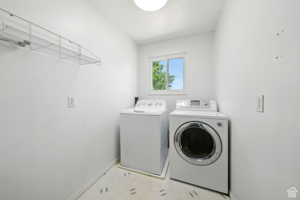Laundry room featuring washer and dryer and light flooring