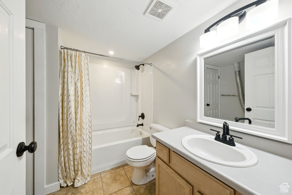 Full bath featuring vanity, shower / tub combo with curtain, and tile patterned flooring