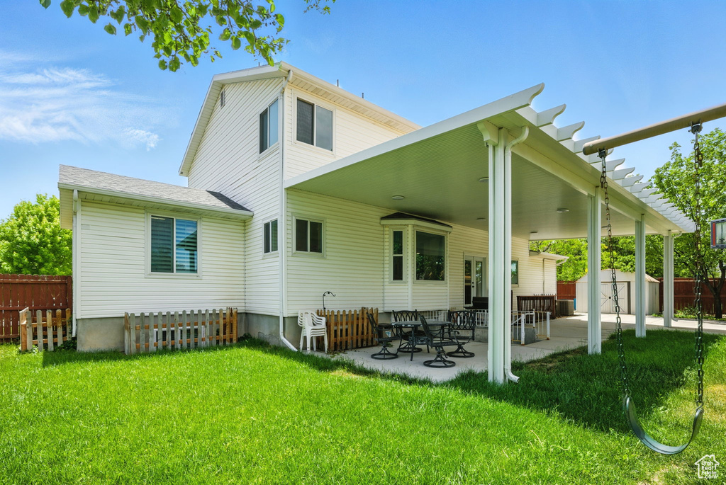 Back of property with a storage shed and a patio area