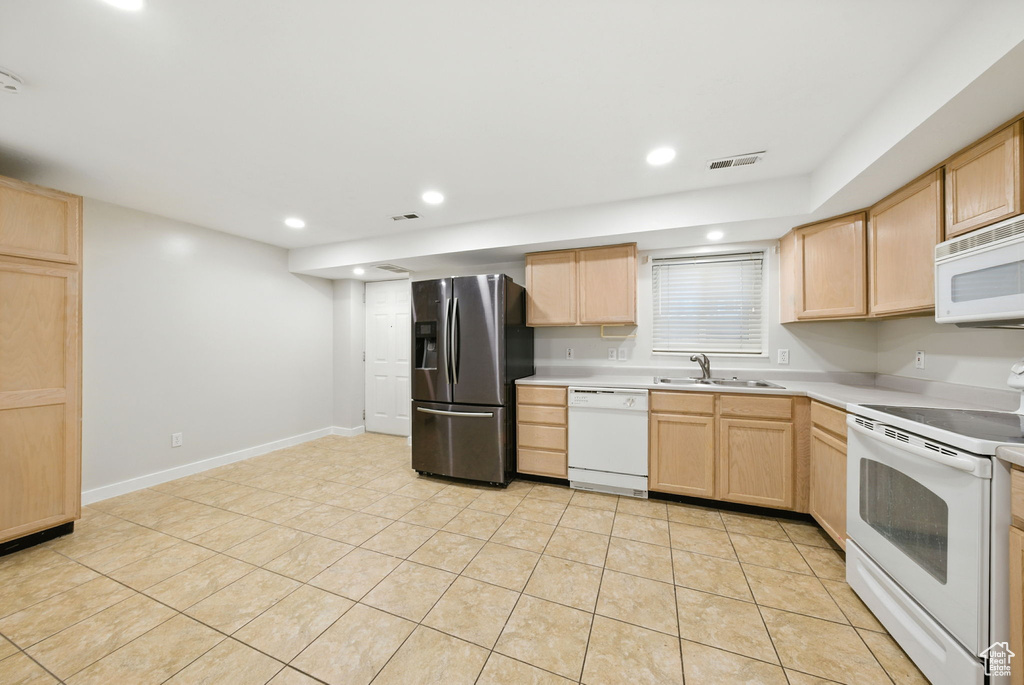 Kitchen with white appliances, light brown cabinetry, light countertops, light tile patterned floors, and recessed lighting