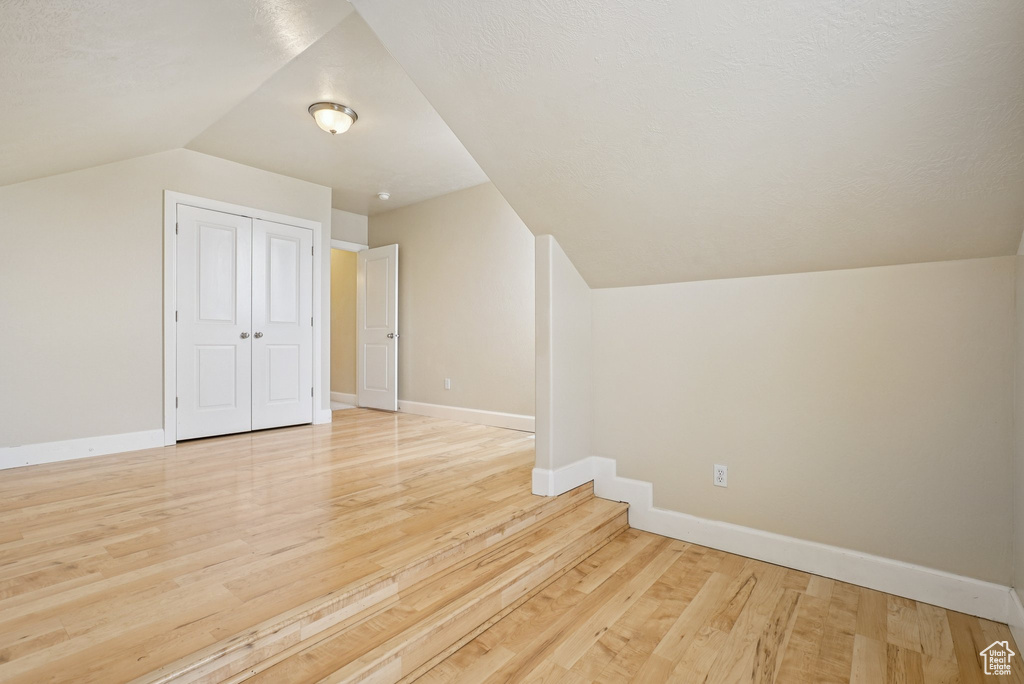 Bonus room featuring vaulted ceiling and light wood-style flooring