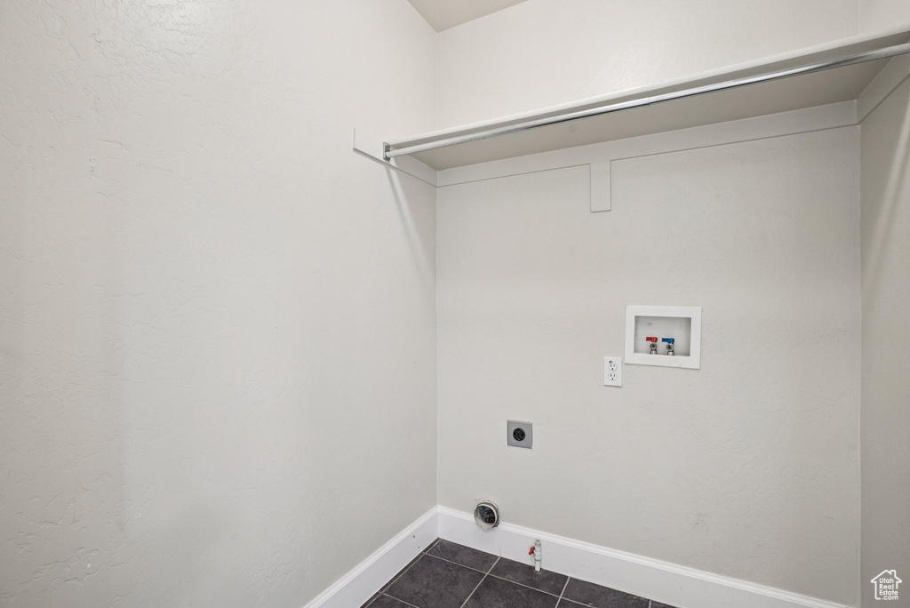 Laundry area featuring washer hookup, dark tile patterned flooring, electric dryer hookup, and hookup for a gas dryer