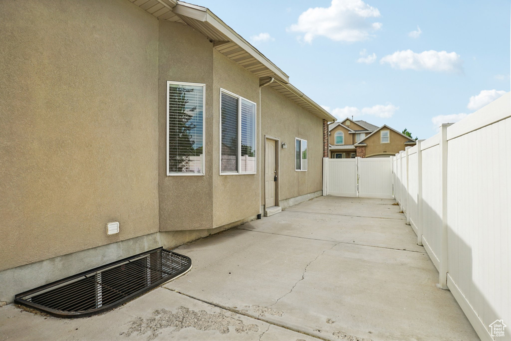 View of property exterior featuring a fenced backyard, a patio, and stucco siding