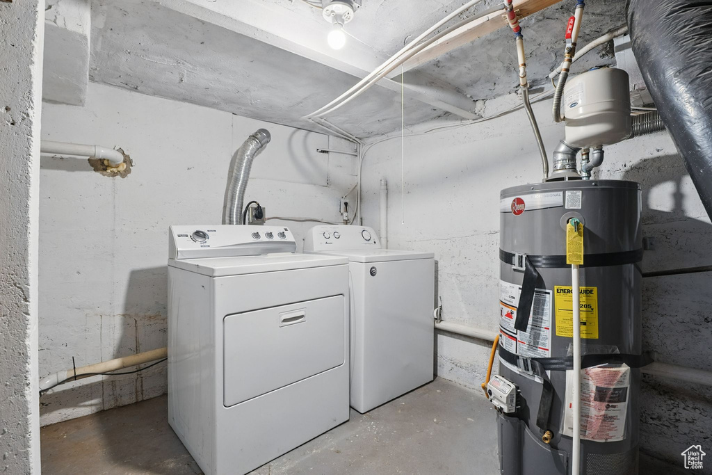 Laundry room with strapped water heater and washing machine and dryer