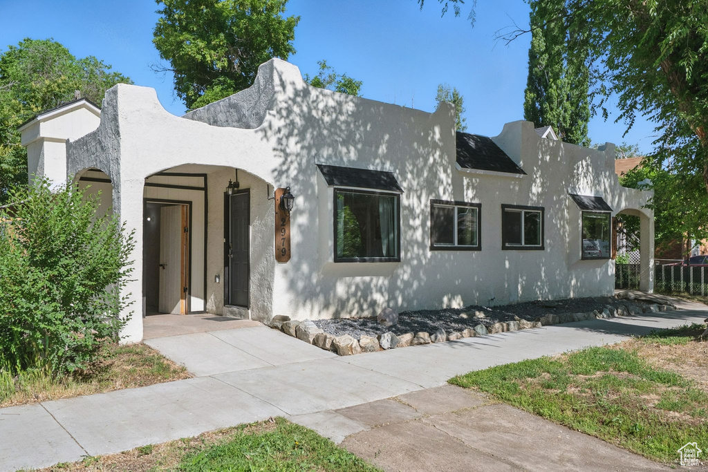 View of front of house featuring stucco siding and driveway