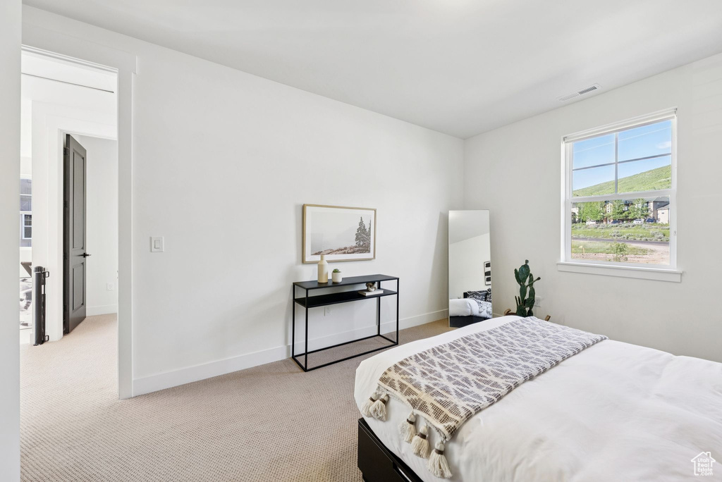 Bedroom featuring light colored carpet
