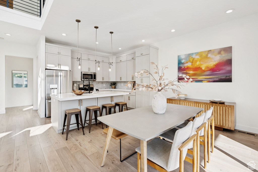 Dining space with recessed lighting and light wood-type flooring