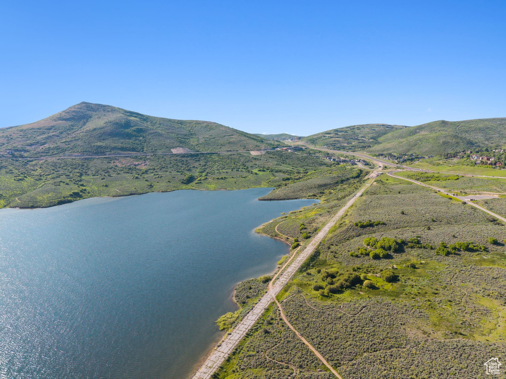 Aerial view of property and surrounding area featuring a water and mountain view