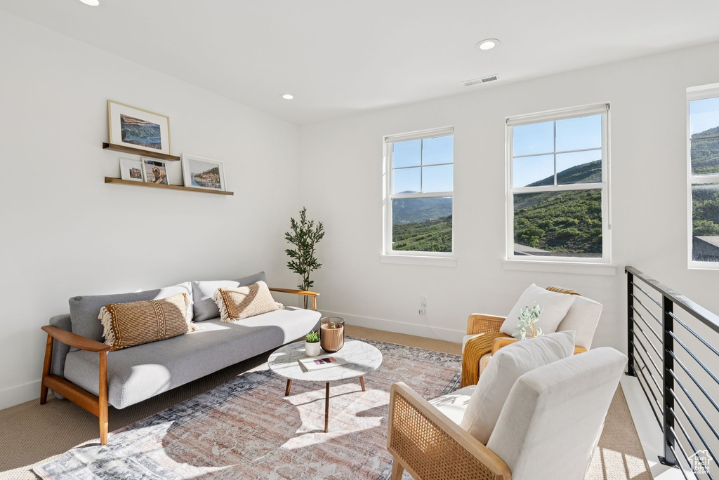 Living area with healthy amount of natural light, carpet flooring, and recessed lighting