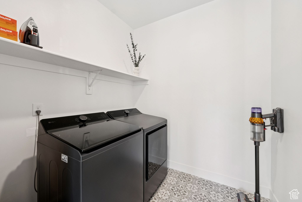 Laundry area with independent washer and dryer and baseboards