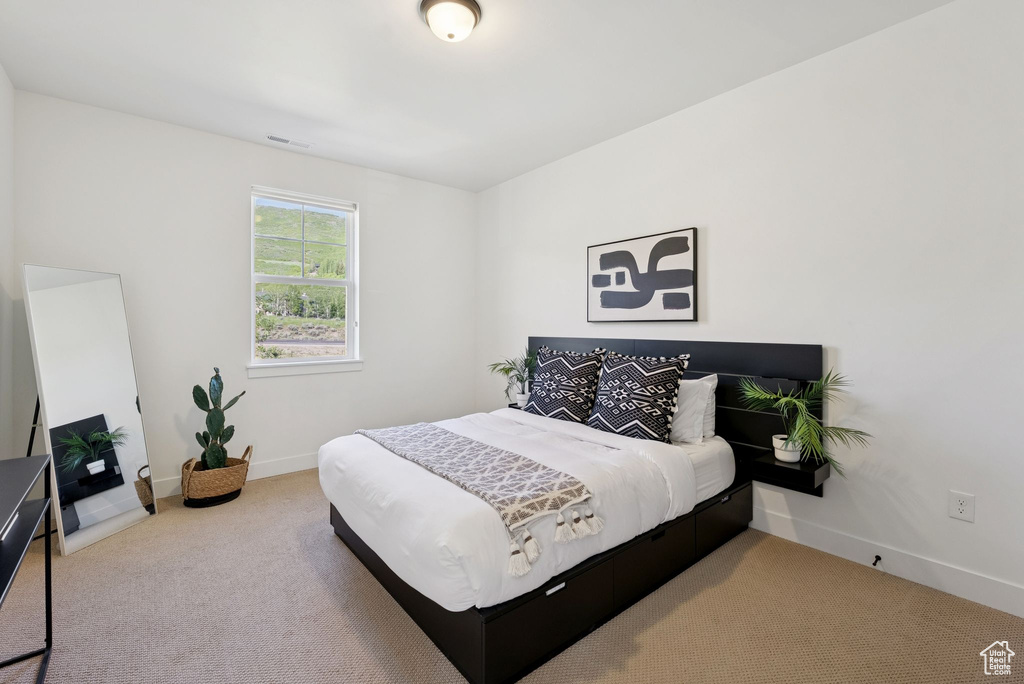 Bedroom featuring carpet and baseboards