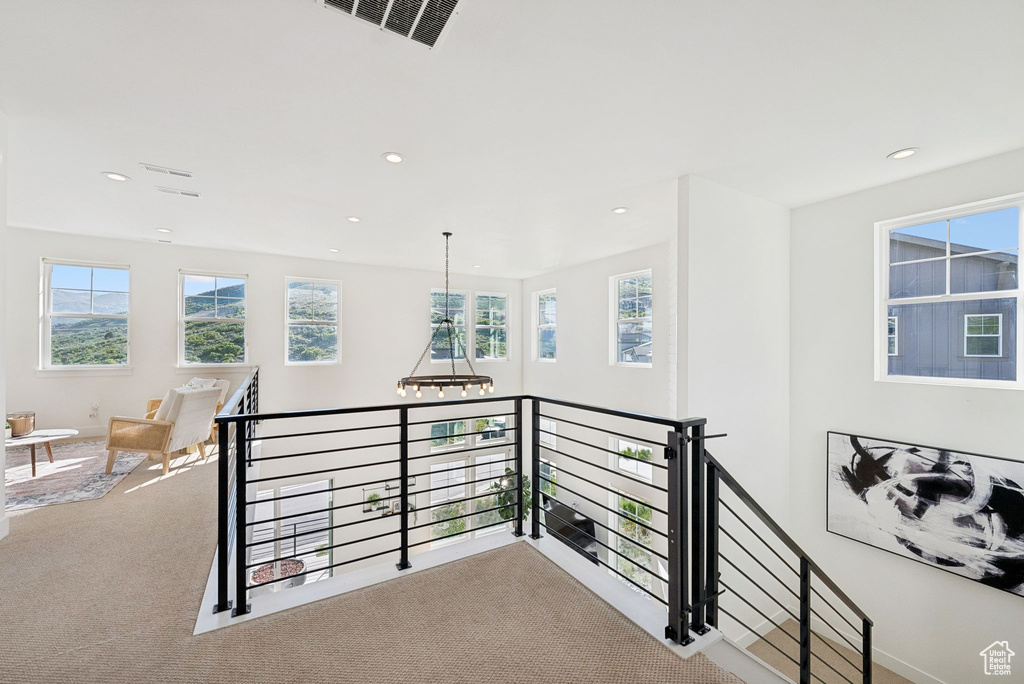 Corridor with carpet flooring, an upstairs landing, plenty of natural light, and recessed lighting