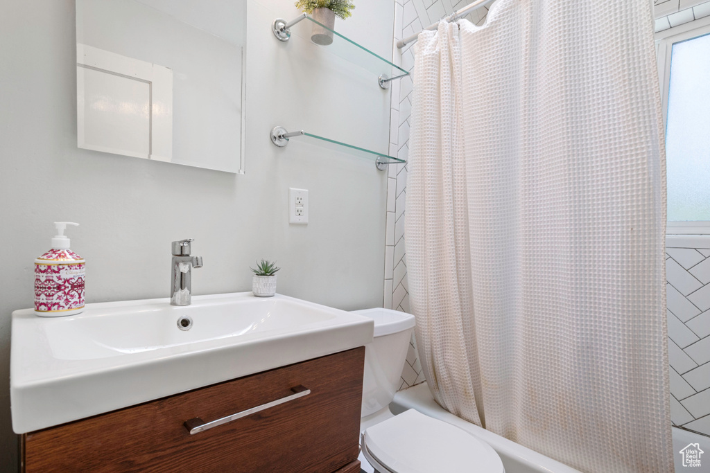 Full bath with shower / bath combo, vanity, and toilet