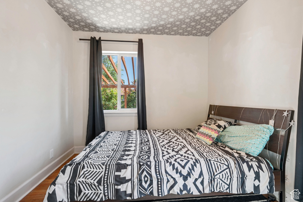 Bedroom featuring wood finished floors and baseboards