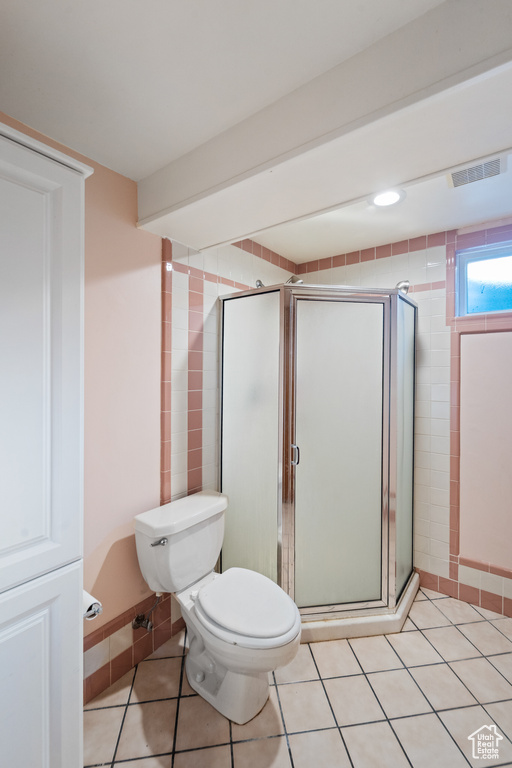 Full bath featuring a stall shower and tile patterned flooring
