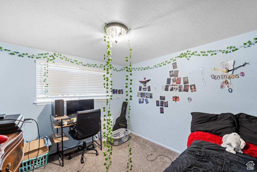 Bedroom featuring a desk, a textured ceiling, and carpet flooring