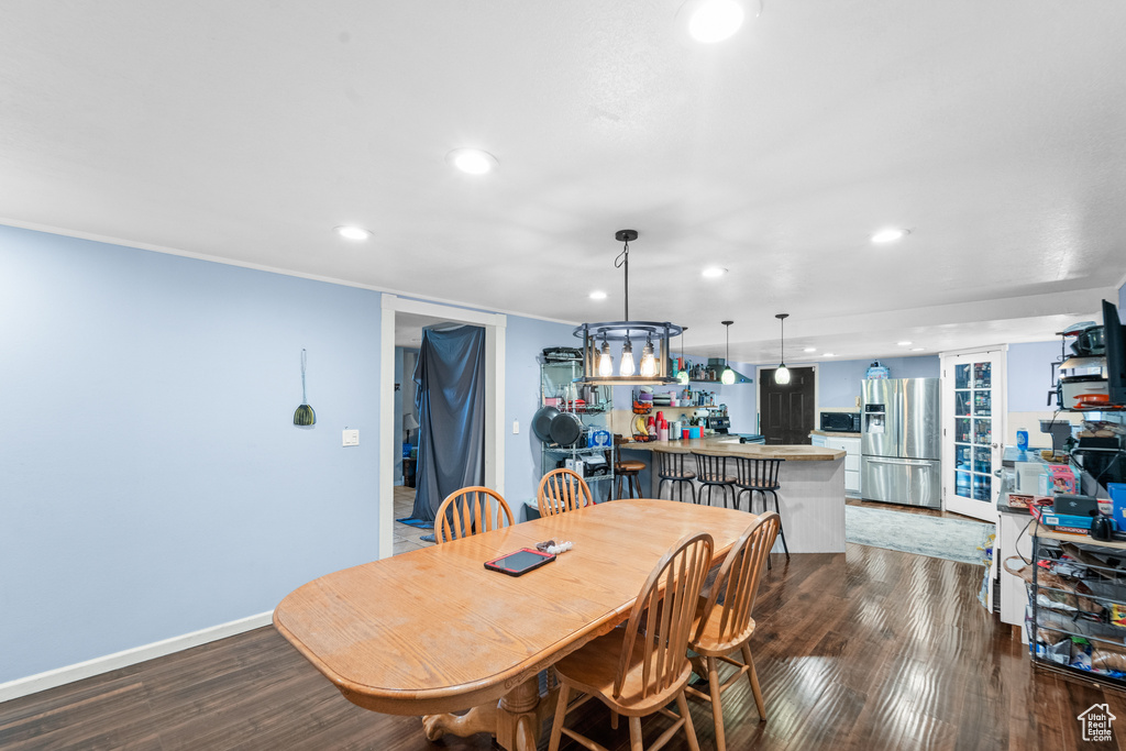 Dining space with wood finished floors, recessed lighting, and a chandelier