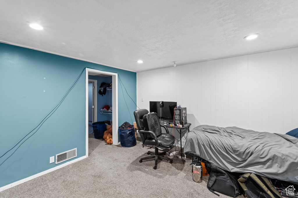 Carpeted bedroom featuring recessed lighting, a walk in closet, a textured ceiling, and an office area
