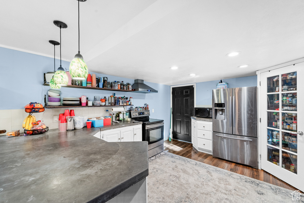Kitchen with stainless steel appliances, open shelves, dark countertops, white cabinets, and dark wood-style floors