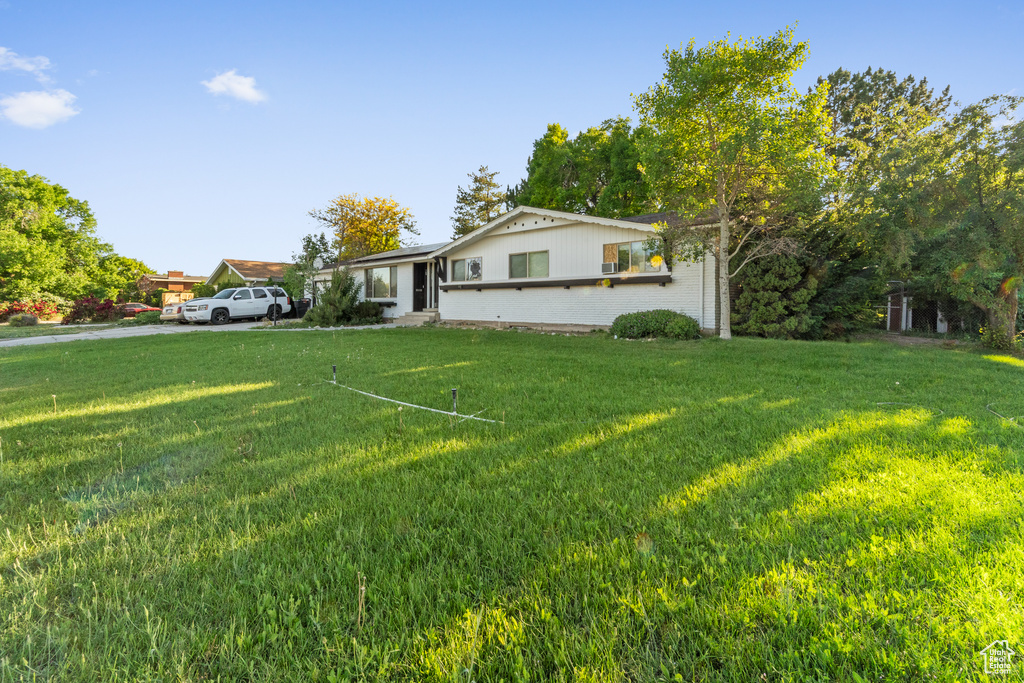 View of front of home with a front yard and brick siding