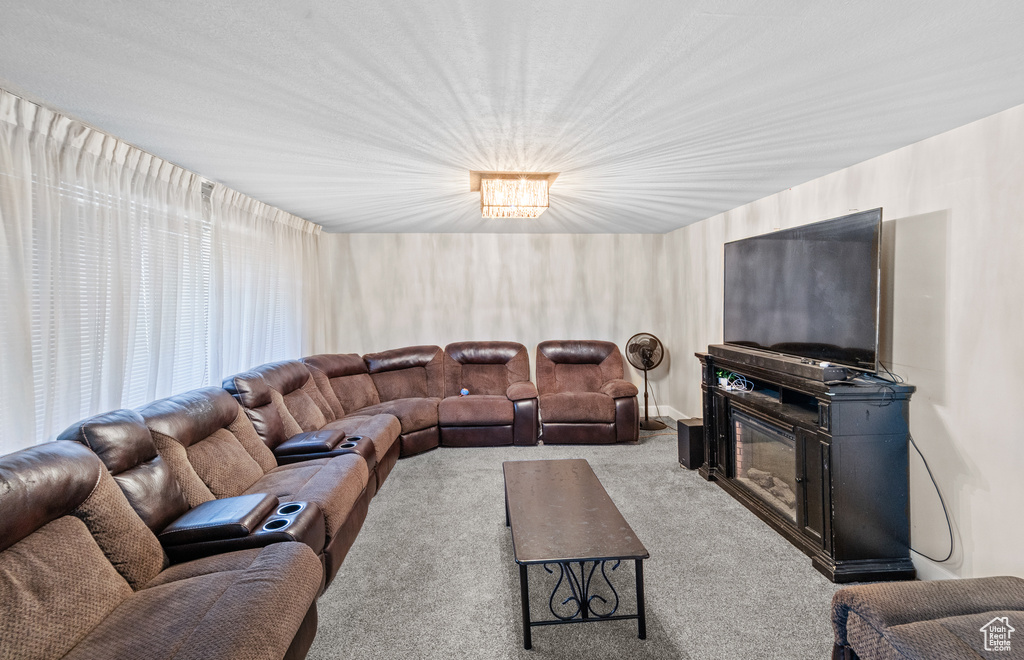 Carpeted living room featuring a glass covered fireplace