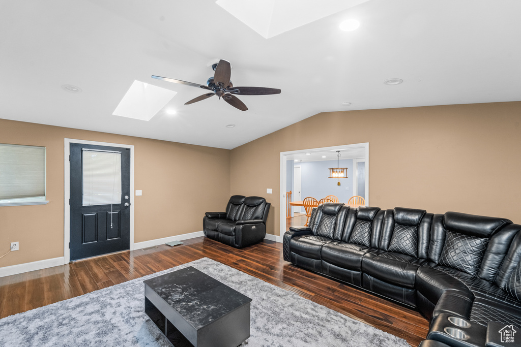 Living area featuring a skylight, wood finished floors, lofted ceiling, a ceiling fan, and recessed lighting