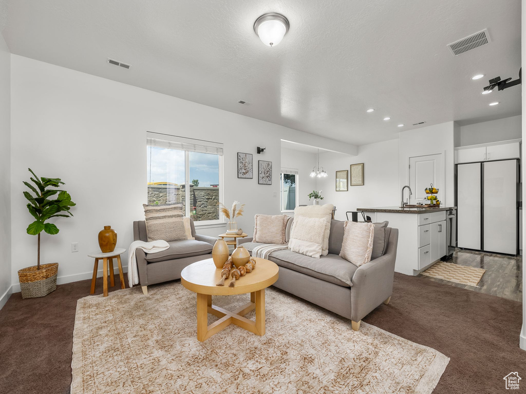 Living room featuring light colored carpet, recessed lighting, and a chandelier