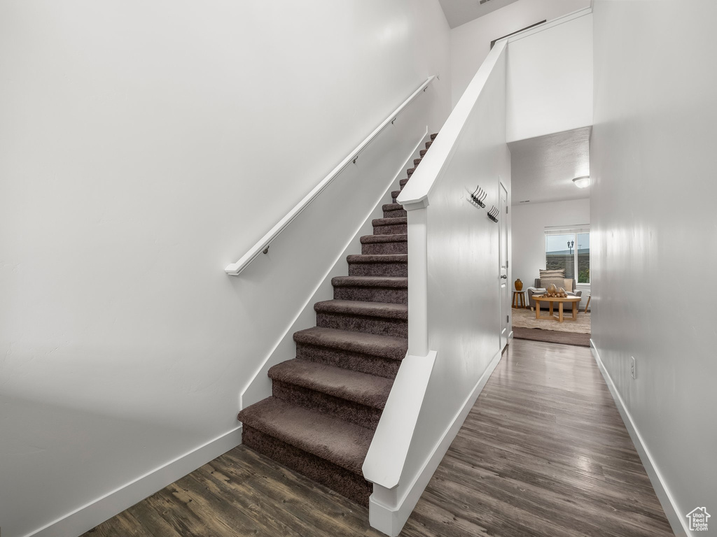Stairway with wood finished floors and baseboards